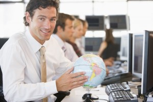 Businessman in office space with a desk globe